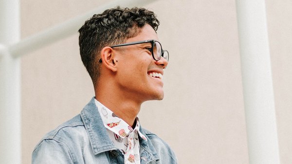 Jonge man glimlacht vol vertrouwen – Je voorbereiden voor loononderhandelingen Jonge man glimlacht vol vertrouwen – Je voorbereiden voor loononderhandelingen