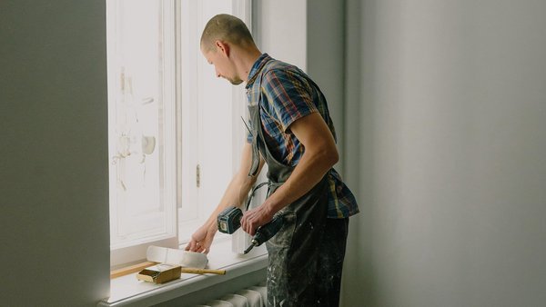 Man herstelt een raam -particuliere arbeidsongeschiktheidsverzekering