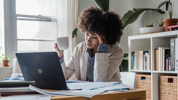 Vrouw zit gestresseerd aan haar bureau - mentale aandoeningen