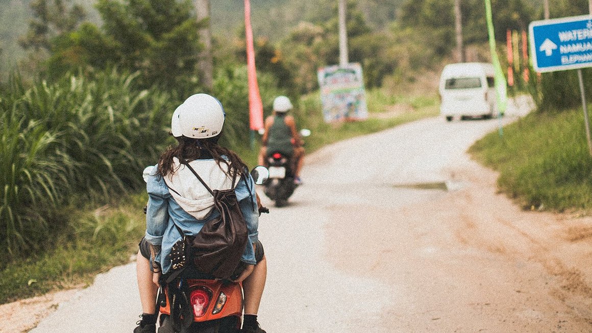 Jonge vrouw op een scooter - backpacking in het buitenland
