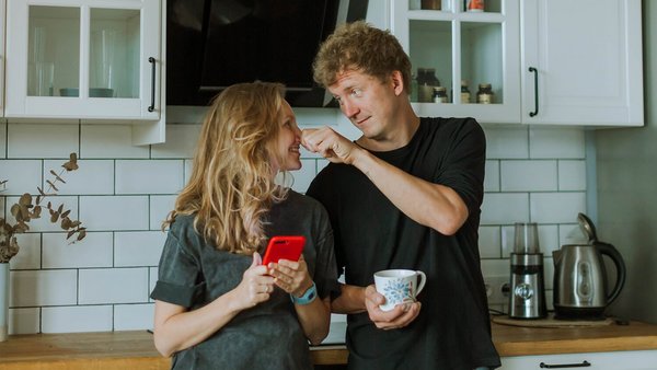 Vrouw en man staan te lachen in de keuken – gezamenlijke rekening