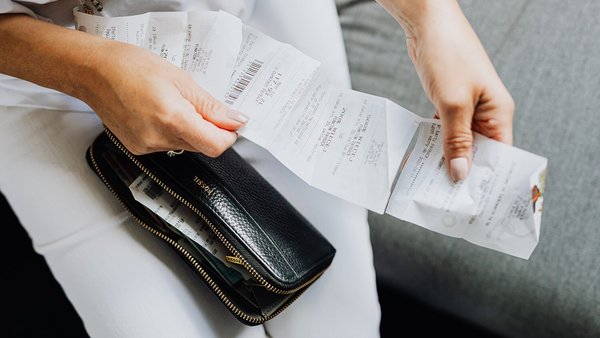 Een vrouw met een rekening in haar hand – stijgende prijzen Een vrouw met een rekening in haar hand – stijgende prijzen
