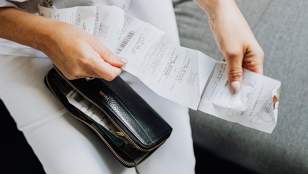 Une femme tient un reçu dans ses mains – hausse de prix