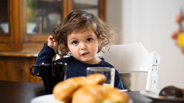 Jeune enfant à la table du petit-déjeuner Jeune enfant à la table du petit-déjeuner