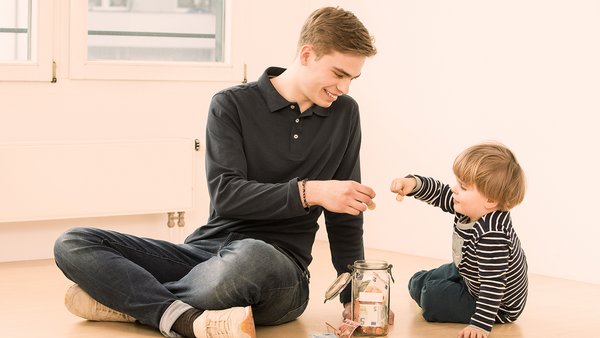 Kindje en jonge man sparen geld in een spaarpot