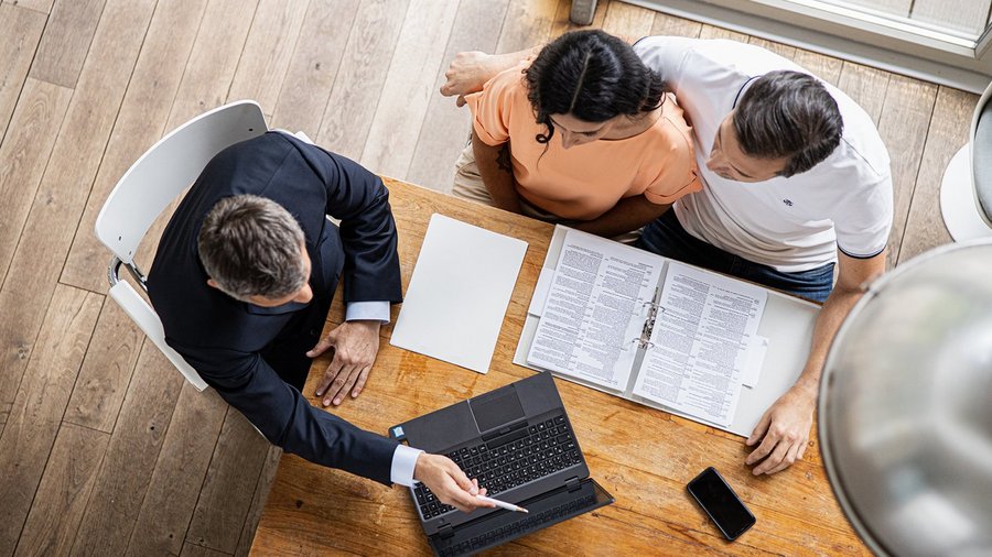 Jong koppel aan tafel met een financieel adviseur van OVB