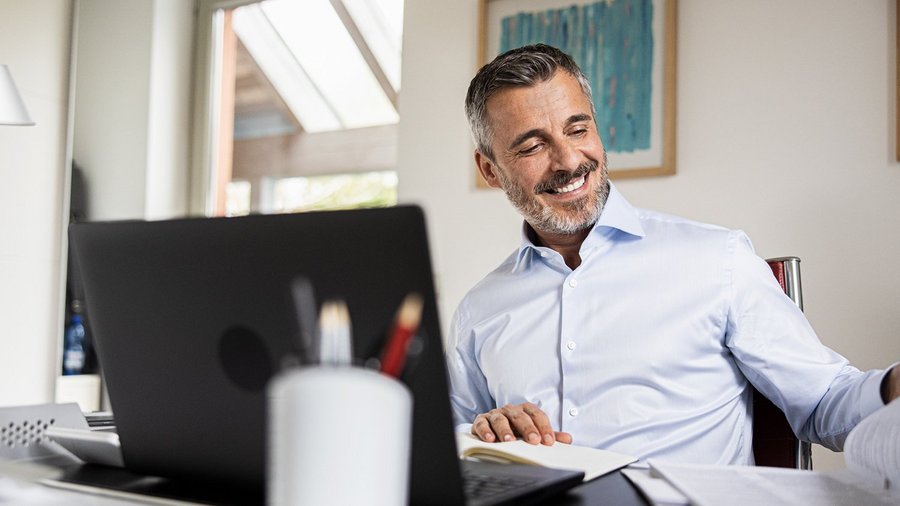 Tevreden financieel adviseur van OVB aan zijn bureau