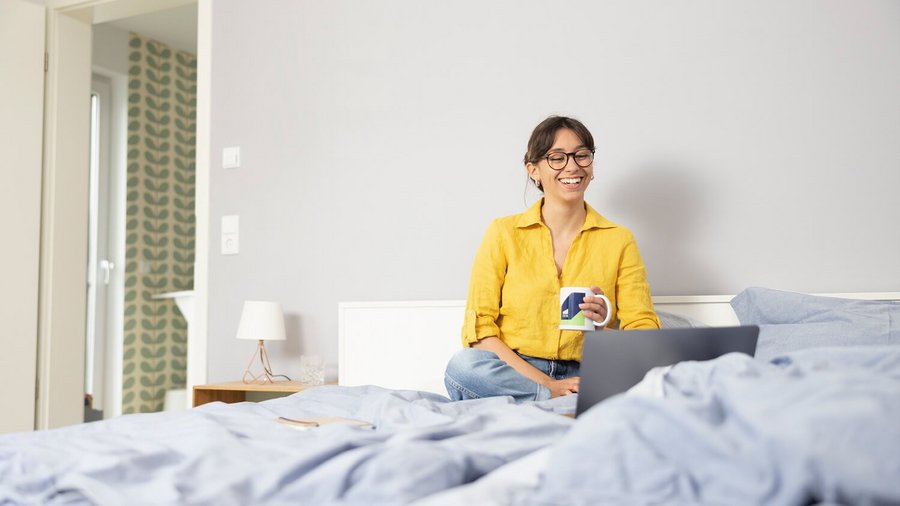  Vrouw al werkend thuis vanuit het bed.