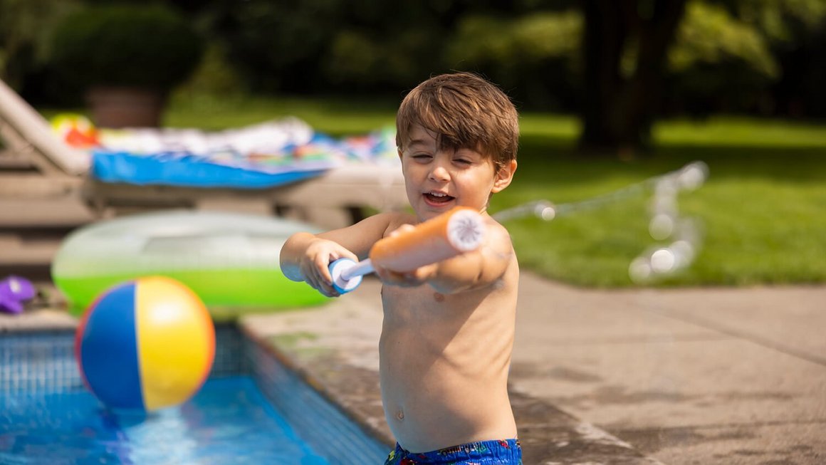 Kind aan het zwembad met een waterpistool – Reis veilig
